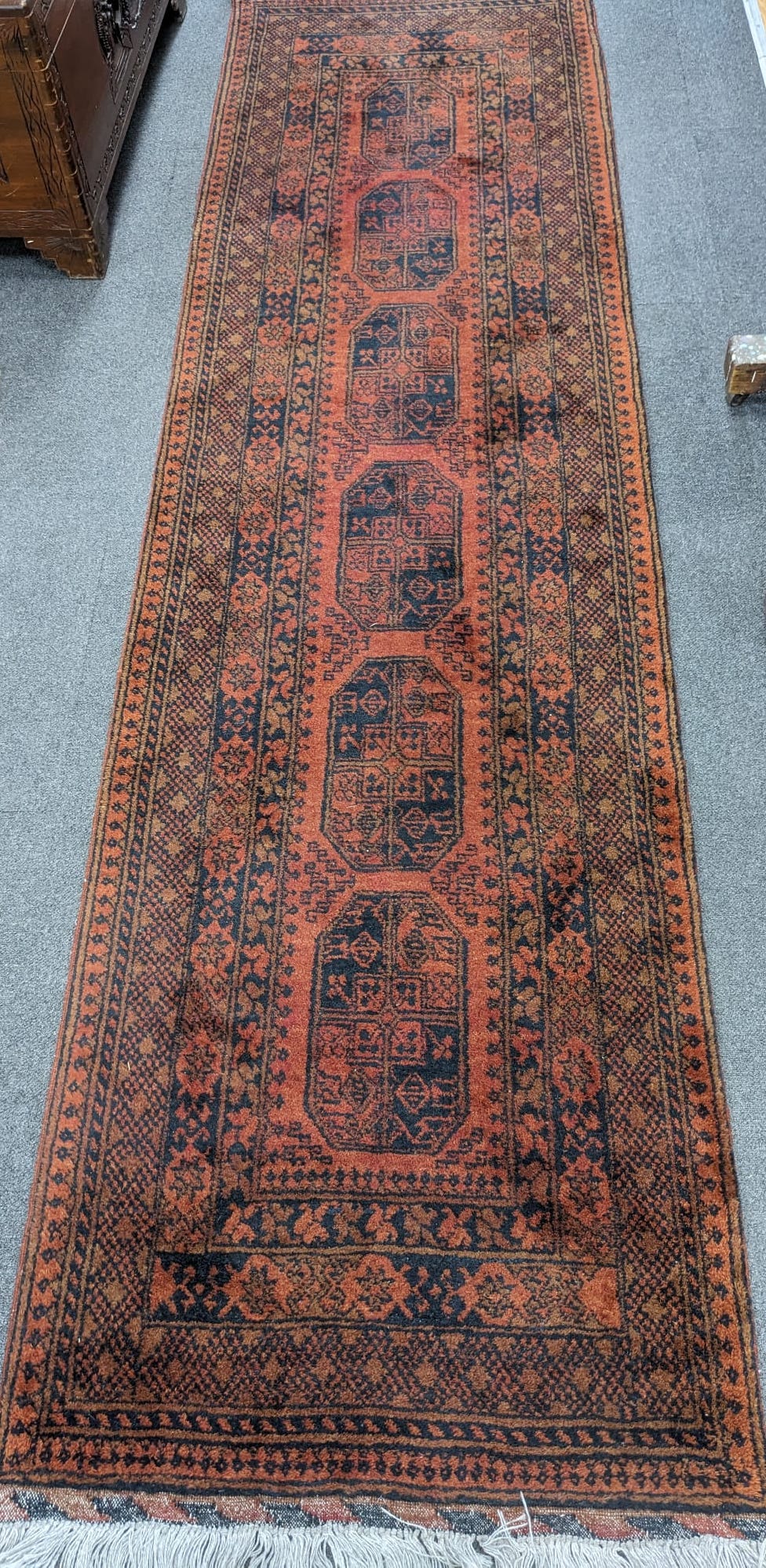 An Afghan red ground runner, 290 x 79cm
